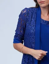 Conjunto de fiesta azul eléctrico, compuesto por un vestido midi de seda fría con aplique de encaje en el escote y una chaqueta corta de encaje con mangas tres cuartos.