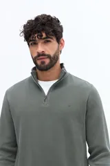 Buzo de algodón color azul marino con medio cierre frontal y cuello alto. Presenta un pequeño logo bordado en el pecho.