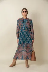 Vestido midi plisado de gasa estampada en tonos violeta y naranja, con lazo en el cuello y en la cintura.