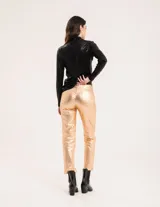 Polera dorada de cuello alto y manga larga, confeccionada en tejido elastizado con terminación metalizada.