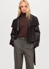 Pantalón gris de tiro medio, diseño recto y largo, con trabillas en la cintura y bolsillos laterales.