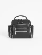 Mochila bandolera de cuero sintético color negro, con múltiples compartimentos frontales y laterales con cierre metálico, asa superior y correas ajustables.