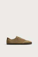 Zapatilla deportiva barefoot de hombre, confeccionada en piel con acabado serraje de color marrón, puntera redondeada, suela fina de goma oscura y detalles en cuero liso en el talón.