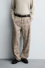 Pantalón de corte relajado confeccionado en tejido ligero de algodón con estampado abstracto de efecto lavado. Presenta cintura elástica, bolsillos frontales y bolsillos traseros de plastrón, con cierre frontal de cremallera y botón.