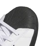 Championes adidas modelo Superstar ADV, de diseño clásico con exterior de cuero blanco, las icónicas tres tiras laterales en negro, puntera de goma negra y suela plana también en color negro.