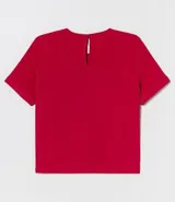 Blusa blanca de poliéster con cuello redondo, mangas cortas, cierre trasero en forma de gota, pequeñas aberturas laterales y acabados en pespuntes en las mangas y el cuello.