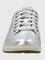 Zapatilla Hush Puppies modelo Spinal de cuero metalizado plateado, con cordones al tono, suela de goma color crema y detalle en el talón. Cuenta con tecnología Spinal para soporte y amortiguación.