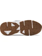 Championes Under Armour modelo Forge 96 Reissue, con diseño inspirado en los años 90. Presenta una parte superior combinada de malla y cuero nobuk en tonos grises y negros, con refuerzos de TPU. Cuenta con una entresuela blanca de amortiguación y suela exterior de goma color caramelo.