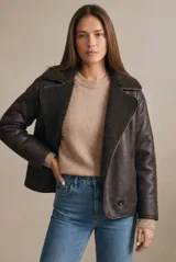Campera tipo gamulan de corte oversize, color marrón oscuro con interior y solapas de corderito al tono. Presenta cierre frontal y mangas largas.