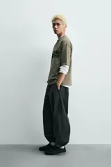 Camiseta de algodón con corte relajado, cuello redondo y manga corta. Presenta un estampado gráfico frontal en color negro con tipografía estilo deportivo y efecto desgastado.