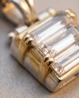 Dije rectangular de plata 925 con lámina de oro 18k y circonias engastadas en corte baguette.
