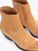 Bota de caña baja confeccionada en cuero descarne color marrón, con diseño de punta fina y tacón bajo de madera.