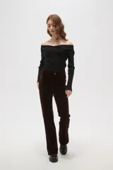 Pantalon de corte flare y tiro alto, confeccionado en tejido de pana color marrón oscuro, con cierre frontal y bolsillos laterales.