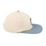 Gorro de visera plana Santa Cruz, con diseño de cinco paneles en color crema y visera azul. Presenta el logo circular de la marca estampado en el frente en color azul.