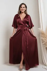 Vestido largo tipo kimono confeccionado en satén color bordó, con escote en V cruzado, mangas amplias y lazo ajustable en la cintura.
