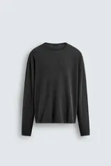 Jersey de manga larga, cuello redondo y calce relajado, color negro con efecto lavado y textura tejida.