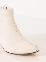 Bota de cuero color blanco con taco acrílico transparente y cierre lateral.