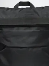 Mochila negra de poliéster con cierre superior enrollable, asa de mano y tirantes ajustables.