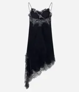 Vestido corto de terciopelo negro, estilo slip dress, con escote corazón, breteles finos y detalles de encaje en el escote y en el ruedo asimétrico con terminación en punta lateral.