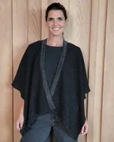 Ruana tejida en algodón con destellos de lurex, de corte amplio y diseño abierto, con textura en punto relieve.