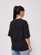Remera negra de algodón con corte oversize y cuello redondo.