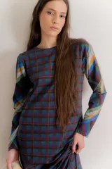 Vestido midi de algodón con estampado de cuadros escoceses en tonos azul, verde, naranja y violeta. Presenta un corte recto, cuello redondo y mangas largas.