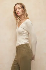 Pantalón de lino color beige, de corte recto y tiro alto, con costuras marcadas en el centro de cada pierna.