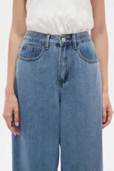 Pantalón jean slouchy de tiro alto, color natural, con detalle de bordadoado en el borde inferior.