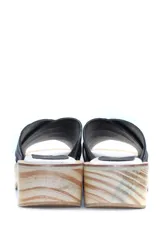 Zueco con plataforma de madera y capellada de cuero negro con textura croco.