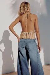 Jeans de tiro medio confeccionados en denim azul con efecto deslavado, corte holgado con diseño de volumen abullonado en las piernas y bajo con puño elástico. Cuentan con trabillas, bolsillos delanteros y traseros, y costuras decorativas marcadas.