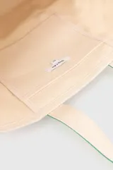 Bolso tote de lona color crema con base y asas en verde. Estampado frontal con el logo de la marca Sporty & Rich.