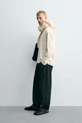 Camiseta de manga larga con corte relajado y cuello redondo. Presenta un diseño de doble capa con acabados en rib a contraste en el cuello y el ruedo.