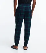 Pantalón de pijama de franela con estampa cuadrillé en tonos azul y verde. Tiene puños elásticos en los tobillos y cordón ajustable en la cintura.
