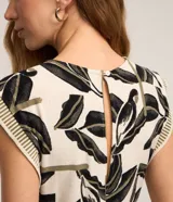 Mono largo de viscosa con estampado de hojas en blanco y negro. Tiene cuello redondo, sisas anchas con detalle de rayas y lazo en la cintura.