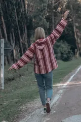 Buzo estilo mexicano con capucha, de tejido grueso a rayas horizontales en tonos rosa y borgoña.