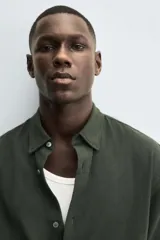 Camisa de corte regular fit confeccionada en tejido de algodón con textura de cuadrillé. Presenta cuello solapa, manga larga con puños abotonados y cierre frontal mediante botonadura.