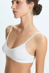 Top deportivo de diseño minimalista, sin costuras, con escote en V y breteles finos. Confeccionado en tejido elástico de tacto suave.