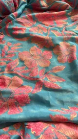 Vestido largo celeste con estampado floral en tonos rosados, escote halter y diseño fluido con volados en la falda.