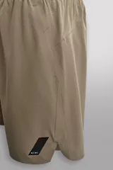 Short deportivo de entrenamiento en tejido técnico ligero y elástico, con cintura elástica ajustable mediante cordón. Presenta bolsillos frontales, un bolsillo trasero con cierre y aberturas laterales en el bajo. Incluye un pequeño logo estampado en la pernera.