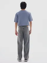 Pantalón de jean gris oscuro con efecto lavado, tiro medio y calce loose con pierna ancha de caída recta.