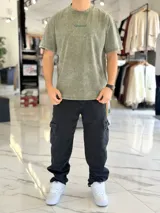Remera oversize gris con efecto acid wash, de mangas cortas y cuello redondo, con estampado tipográfico blanco en la espalda.