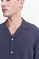 Camisa blanca de manga corta con textura, fit regular y logo bordado.