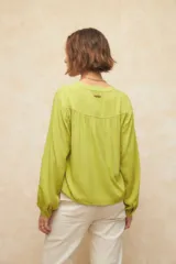 Camisa verde lima de manga larga con cuello mao y escote en V. Cuenta con botones forrados en la misma tela y puños elásticos.