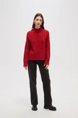 Polera de tejido de punto color crema, con cuello alto y diseño de trenzas verticales. Presenta mangas largas con puños acanalados y un corte holgado.