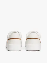 Zapatillas de corte bajo Tommy Hilfiger con diseño inspirado en el tenis, confeccionadas en piel napa blanca con paneles laterales de gamuza en color marrón. Presentan cierre con cordones, suela de goma y detalles de logo en bajo relieve.