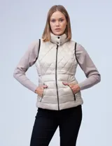 Chaleco capitoneado color rosa claro, con cuello alto, cierre frontal y bolsillos laterales.