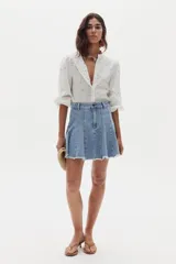Minifalda de denim con diseño de godets y ruedo desflecado, confeccionada en algodón con elastano.