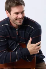 Buzo de algodón tejido color azul marino con rayas horizontales en beige y bordó. Presenta cuello alto con medio cierre frontal y puños y dobladillo acanalados.