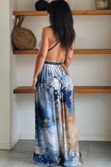 Vestido largo de seda con estampado abstracto en tonos marrones, beige y destellos dorados, con escote en V profundo, tirantes de cuerda anudados al cuello y la cintura, y tajo lateral en la falda.