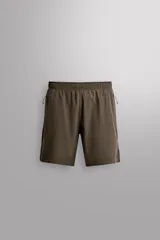 Shorts deportivos de entrenamiento Zara Athleticz, color beige, confeccionados en tejido técnico ligero y elástico con forro interior. Presentan cintura elástica ajustable, bolsillos frontales, bolsillo trasero de seguridad con cierre, aberturas laterales en el bajo y detalle de logo estampado en la pierna.